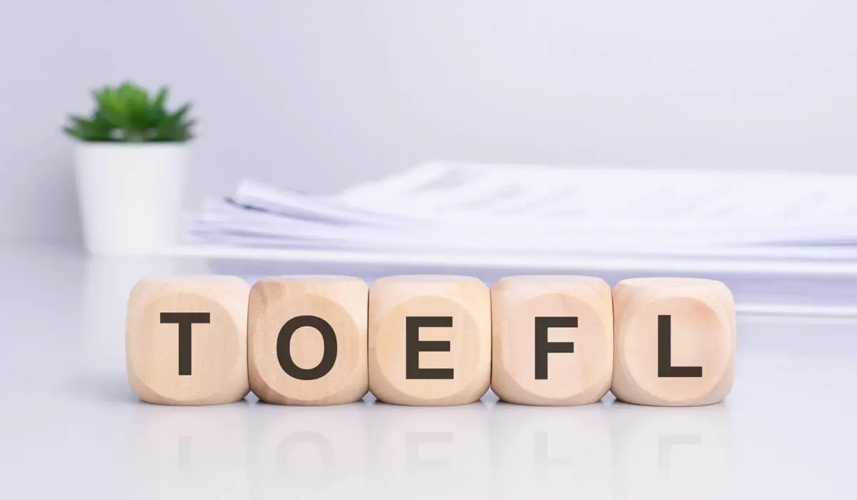 Vários cubos de madeira sobre a mesa formando a palavra TOEFL